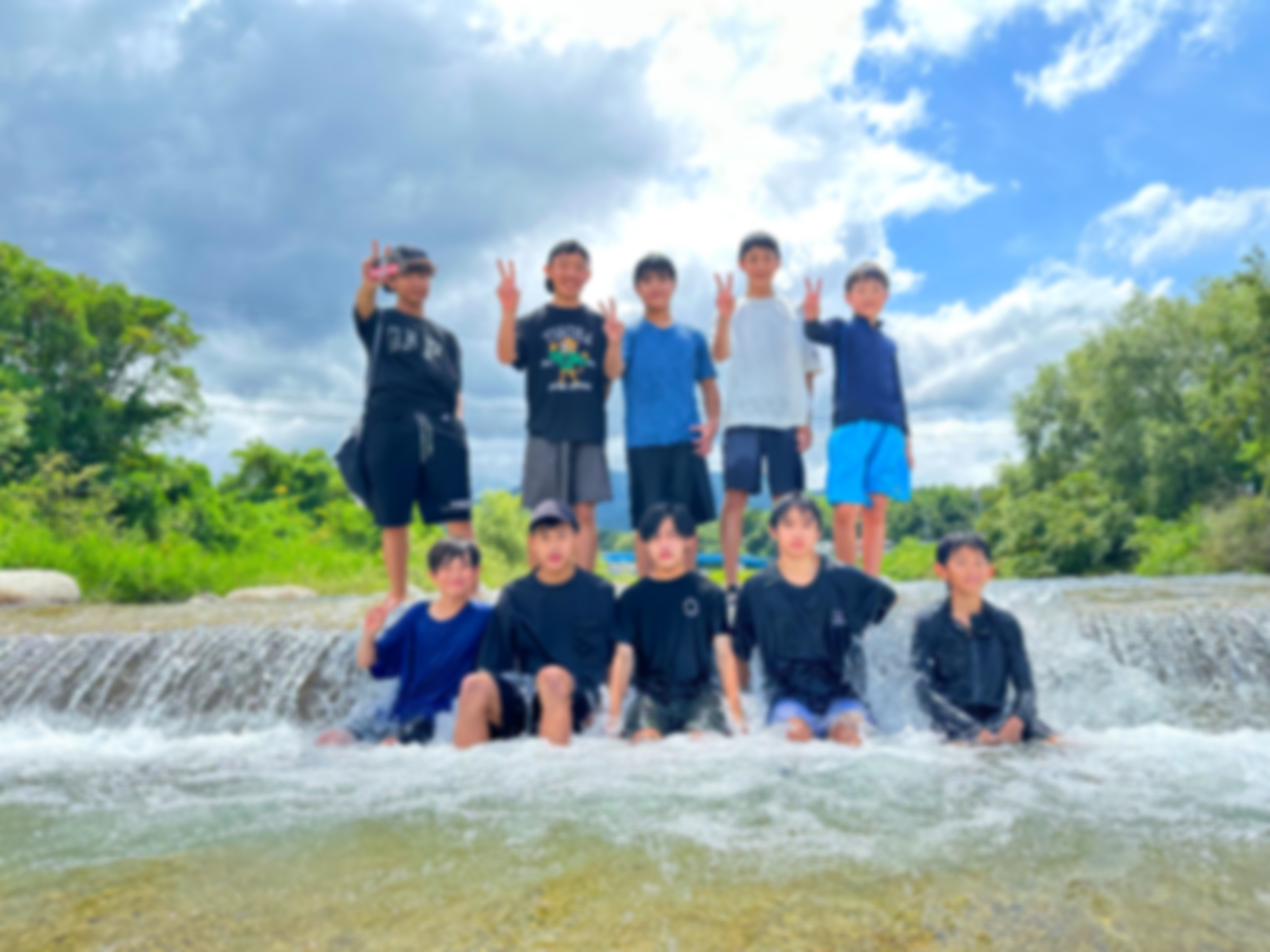 BBQでの交流のひとこま。川に集まってポーズをとるメンバー