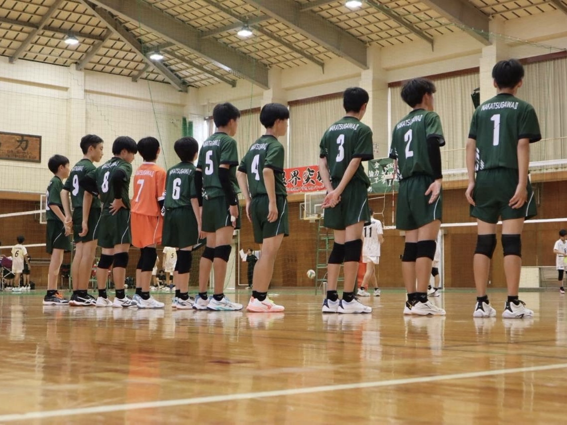 大会会場のコートに、緑のユニフォームで並ぶメンバー